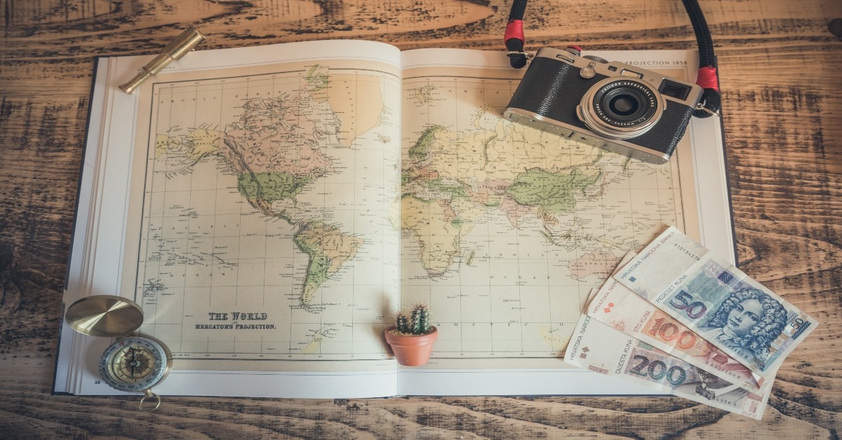 travel essentials laid out on a world map