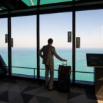 businessman at the airport window looking at sea