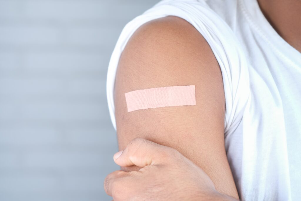 person with plaster on arm after vaccine