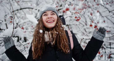 Portrait of girl at winter snowy day near snow covered trees.